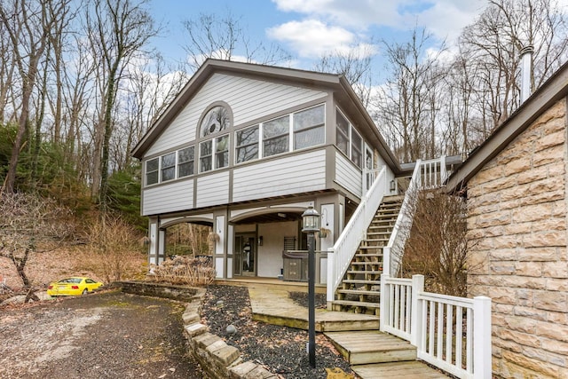 view of front of house with stairs and a sunroom