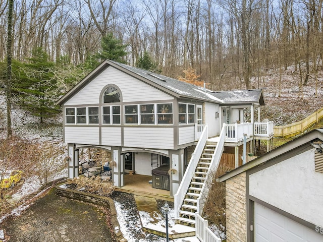 rear view of house with a sunroom, a patio area, and stairway