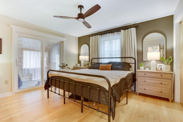 bedroom featuring light wood-type flooring, access to exterior, and multiple windows