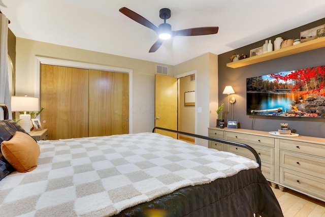 bedroom with light wood-style flooring, visible vents, and a ceiling fan