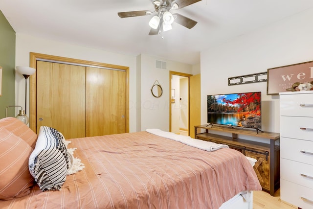 bedroom with a closet, visible vents, ceiling fan, and light wood finished floors