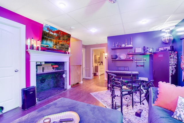 bar featuring a fireplace, a drop ceiling, and wood finished floors