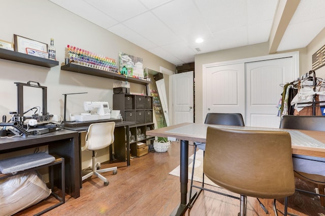 office area with a drop ceiling and wood finished floors