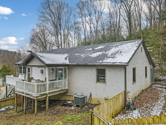 rear view of property with central AC, a shingled roof, stairway, a wooden deck, and stucco siding