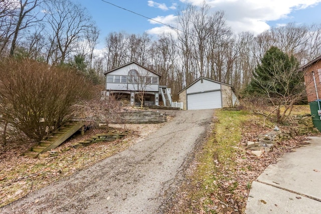 view of front of property featuring stairs, an outdoor structure, and a detached garage