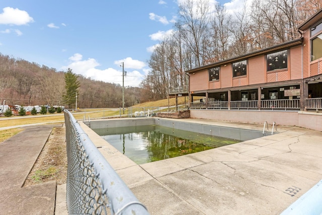 view of swimming pool featuring fence