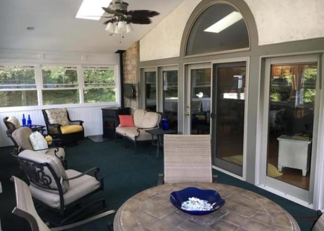 sunroom / solarium with ceiling fan and vaulted ceiling with skylight