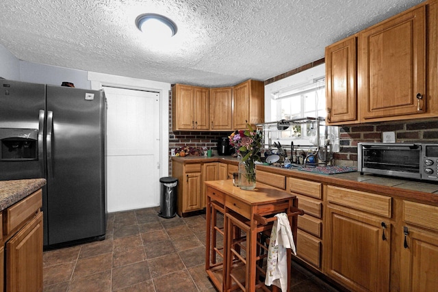 kitchen with tasteful backsplash, a toaster, refrigerator with ice dispenser, and brown cabinets