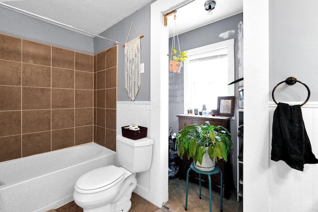 full bathroom with bathing tub / shower combination, toilet, wainscoting, vanity, and tile patterned flooring