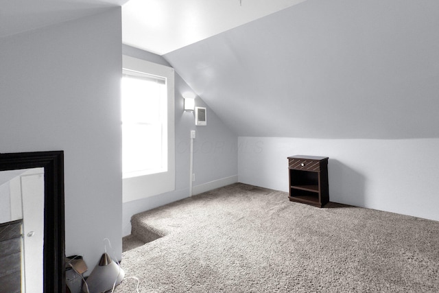 bonus room with vaulted ceiling and carpet flooring