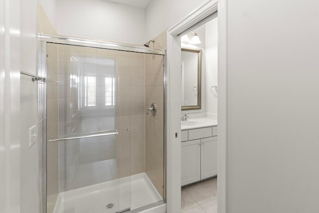 bathroom with tile patterned flooring, a shower stall, and vanity