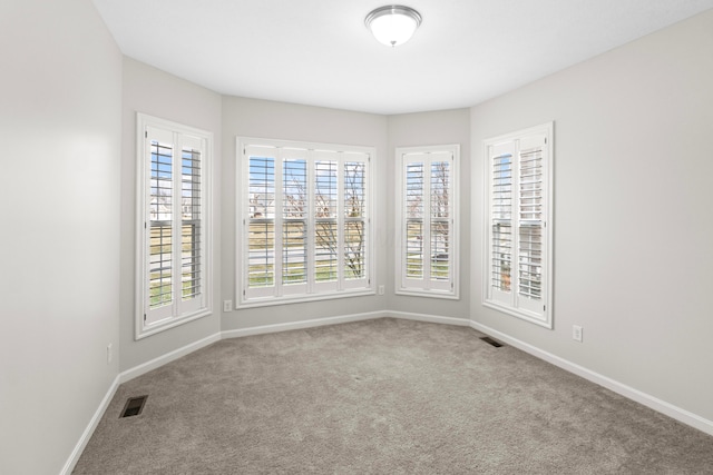 carpeted empty room with baseboards and visible vents