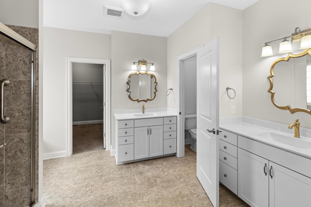 bathroom with toilet, a shower stall, visible vents, and a sink