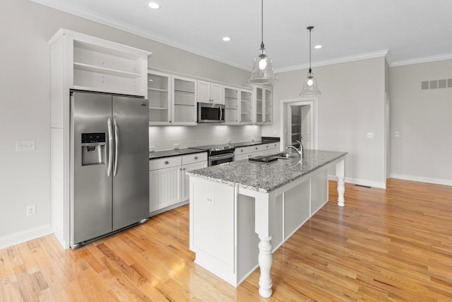 kitchen featuring visible vents, decorative backsplash, appliances with stainless steel finishes, ornamental molding, and light wood-type flooring