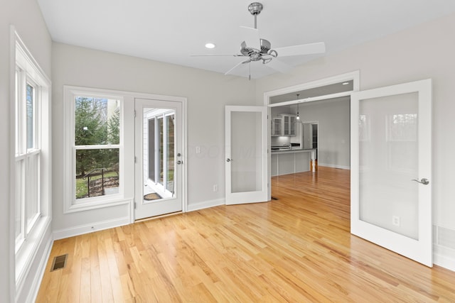 spare room with visible vents, baseboards, a ceiling fan, light wood-style flooring, and french doors