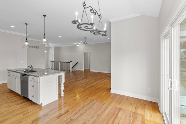 kitchen with light wood-style flooring, a sink, white cabinetry, a center island with sink, and crown molding