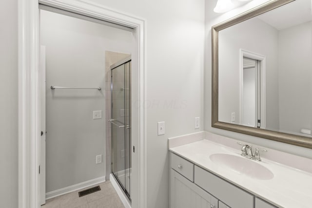 full bathroom featuring a stall shower, visible vents, baseboards, tile patterned flooring, and vanity