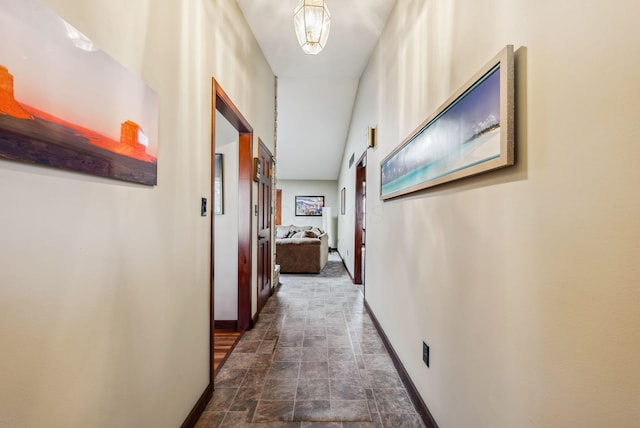 corridor with stone finish flooring and baseboards