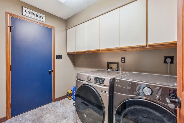 clothes washing area with washing machine and clothes dryer, cabinet space, and baseboards