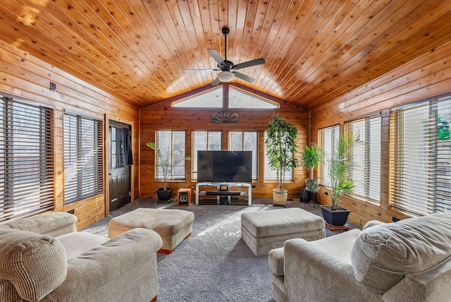 carpeted living room with a ceiling fan, lofted ceiling, wood ceiling, and wood walls