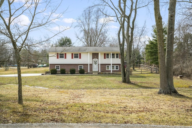 bi-level home featuring a front yard, brick siding, fence, and entry steps