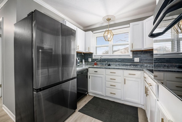 kitchen featuring black dishwasher, stainless steel refrigerator, light wood-style floors, white cabinetry, and a sink