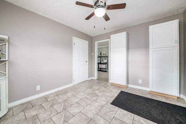 interior space with ceiling fan and baseboards