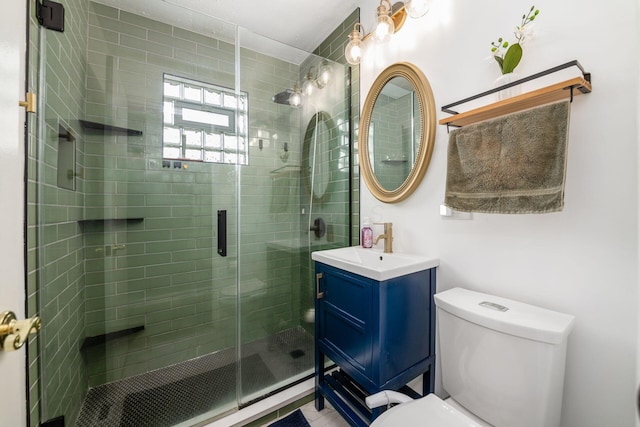 full bathroom featuring toilet, a stall shower, and vanity