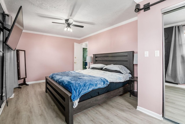 bedroom with a textured ceiling, a barn door, wood finished floors, and crown molding