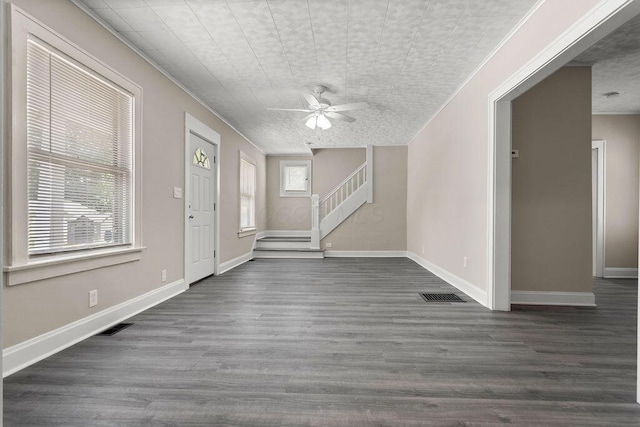 entrance foyer with a wealth of natural light, dark wood-style flooring, visible vents, and stairs