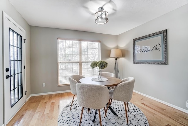 dining space featuring baseboards and light wood-style floors