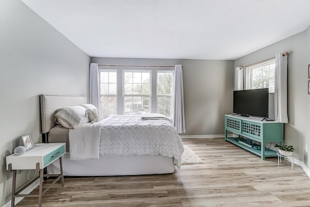 bedroom featuring baseboards and wood finished floors