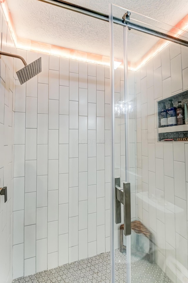 bathroom with a textured ceiling and a shower stall