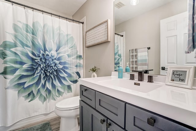 full bathroom featuring visible vents, a shower with shower curtain, toilet, vanity, and wood finished floors