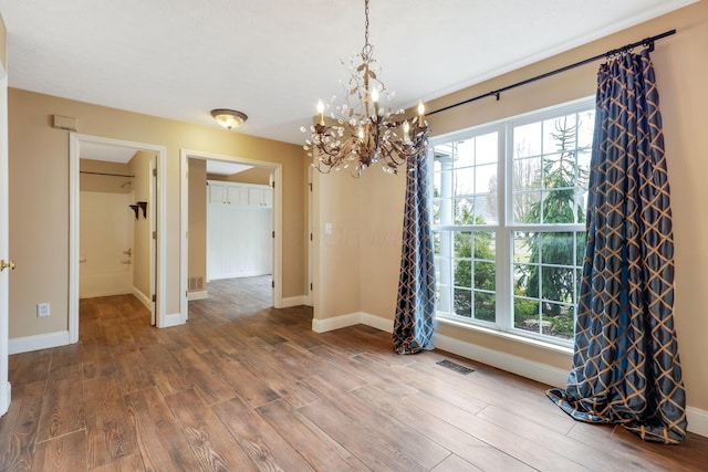 unfurnished dining area featuring a wealth of natural light, wood finished floors, and visible vents