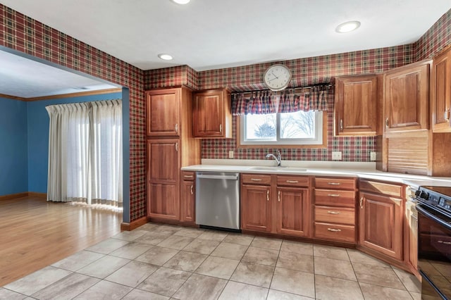 kitchen with dishwasher, light countertops, a sink, and range