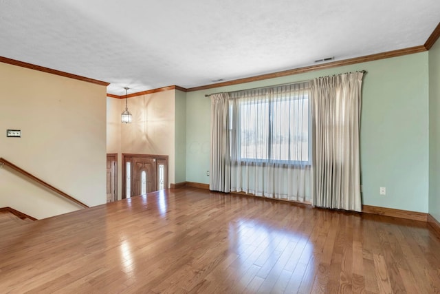 unfurnished living room with ornamental molding, baseboards, and wood finished floors