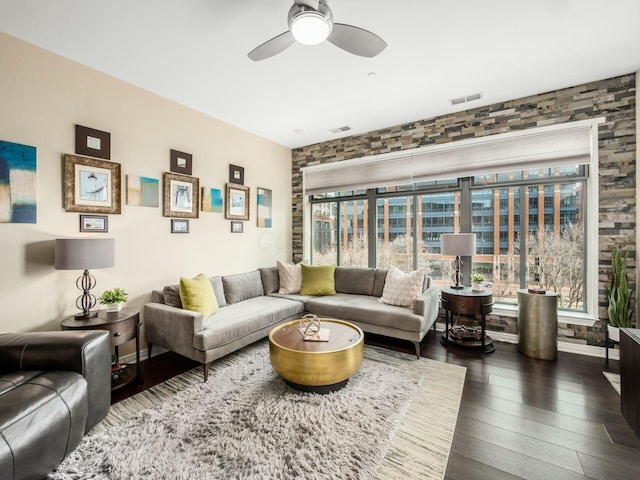 living area with baseboards, visible vents, ceiling fan, and hardwood / wood-style floors