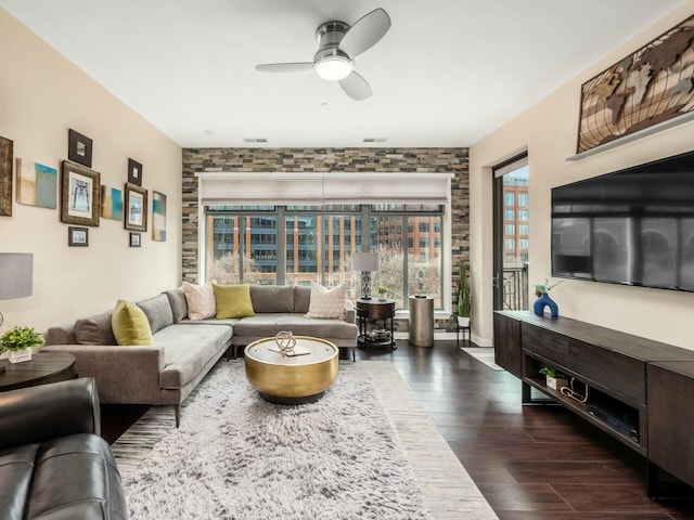 living room featuring visible vents, dark wood finished floors, and a ceiling fan