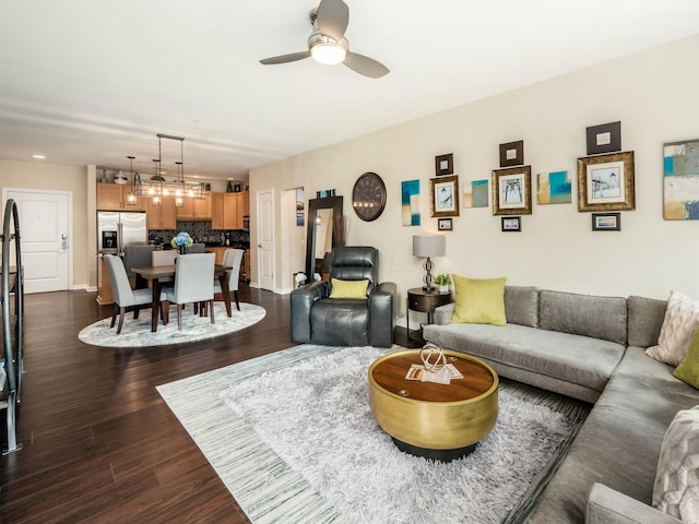 living room featuring ceiling fan and dark wood-style flooring