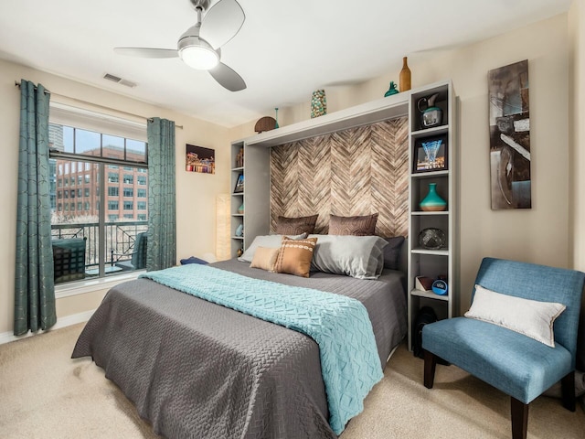 bedroom with visible vents, a ceiling fan, and light colored carpet