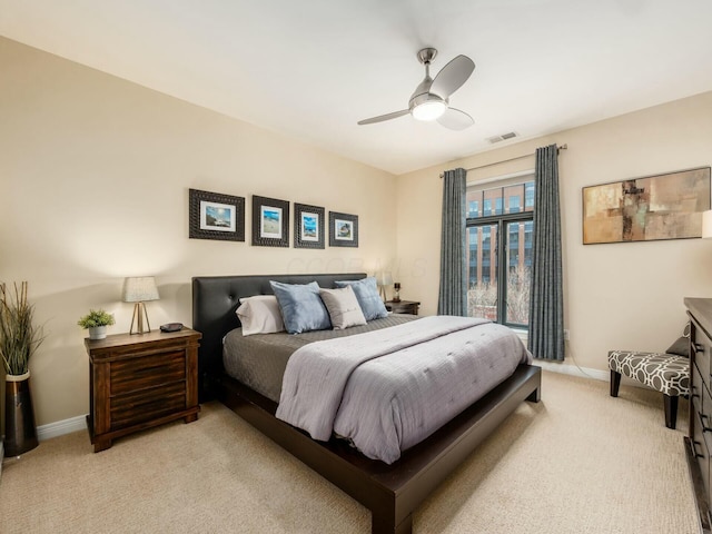 bedroom featuring a ceiling fan, light colored carpet, visible vents, and baseboards