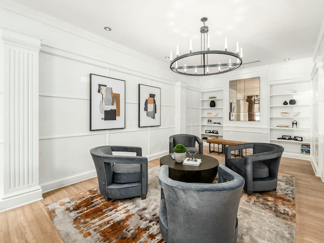 living area with a chandelier, wood finished floors, and crown molding