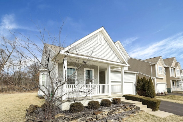 view of front of property featuring a garage, covered porch, and driveway