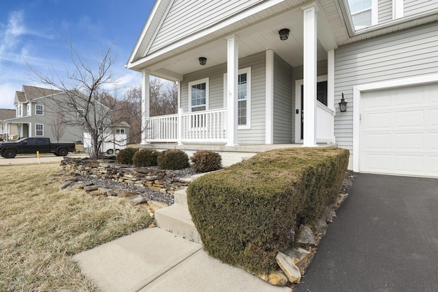 property entrance featuring a porch and aphalt driveway