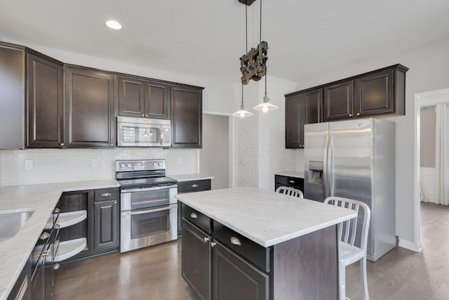 kitchen with stainless steel appliances, dark wood-style flooring, dark brown cabinets, and tasteful backsplash