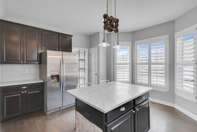 kitchen featuring plenty of natural light, stainless steel fridge, dark wood finished floors, and decorative backsplash