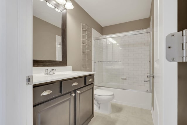 bathroom with toilet, bath / shower combo with glass door, vanity, and tile patterned floors