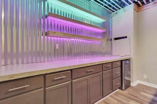 kitchen featuring wine cooler, light wood finished floors, open shelves, light countertops, and baseboards