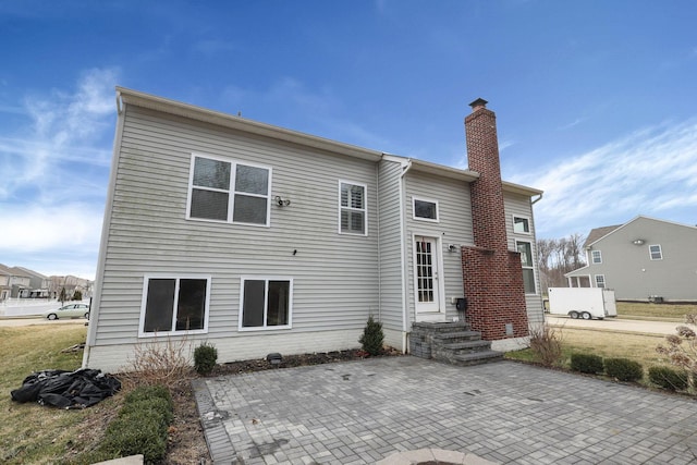 rear view of house with a patio area and a chimney